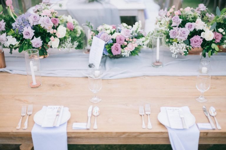 Banquet table with flower bouquets and cutlery on wedding day